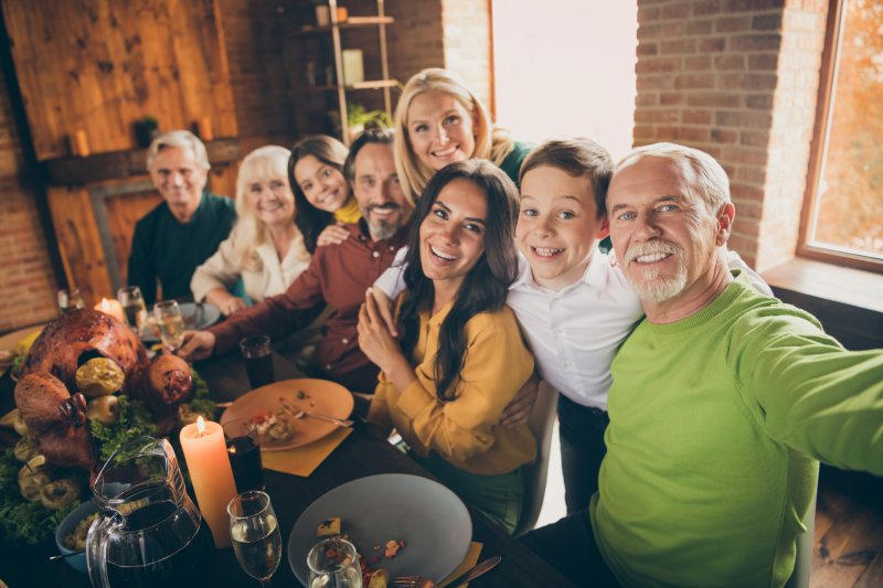 A selfie of a smiling family sitting down for Thanksgiving